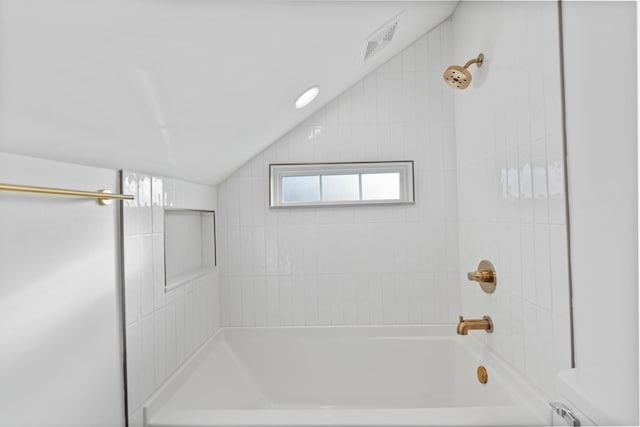 bathroom featuring tiled shower / bath combo and vaulted ceiling