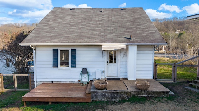 back of house with an outdoor fire pit and a deck