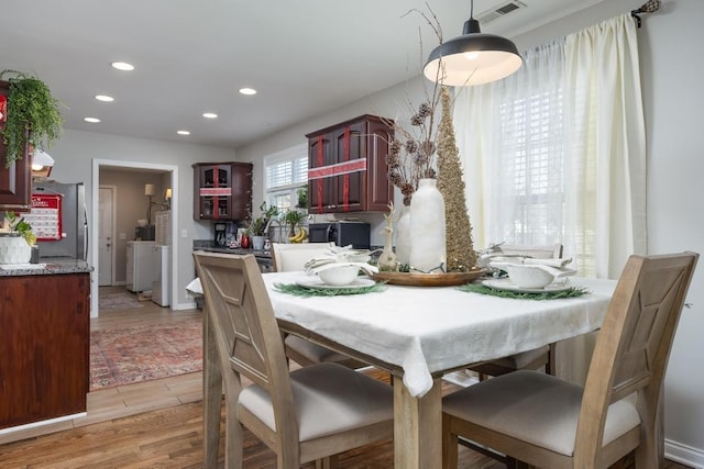 dining space featuring independent washer and dryer and light wood-type flooring