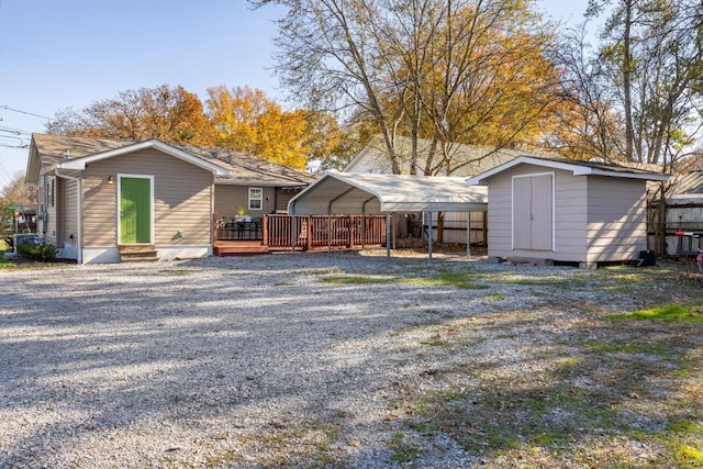 rear view of property with a storage shed and a carport