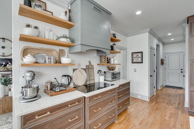 kitchen with tasteful backsplash, light stone counters, crown molding, black electric stovetop, and light wood-type flooring