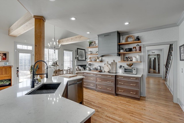 kitchen featuring dishwasher, sink, hanging light fixtures, light hardwood / wood-style flooring, and light stone counters