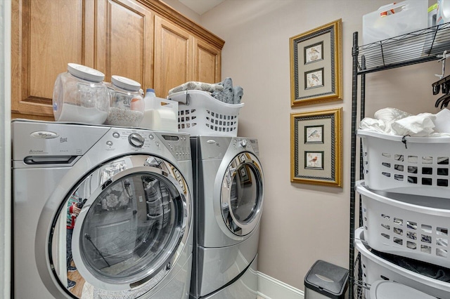 washroom with cabinets and washer and clothes dryer