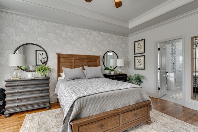 bedroom featuring ensuite bathroom, hardwood / wood-style floors, ceiling fan, and crown molding