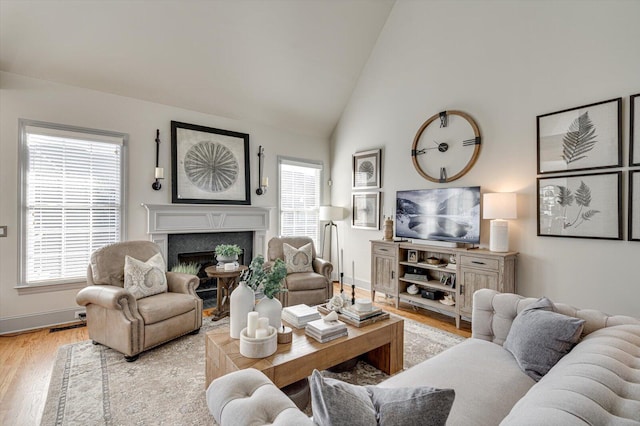 living room with high vaulted ceiling and light wood-type flooring