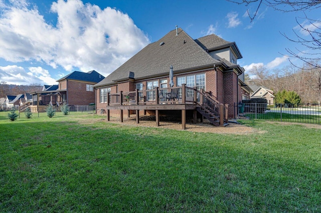 rear view of house with a lawn and a wooden deck