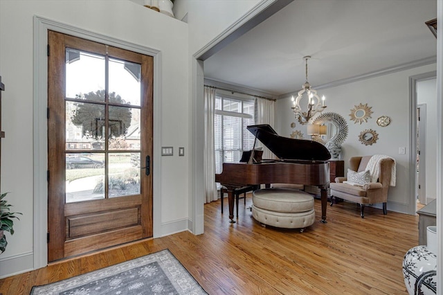 entrance foyer featuring an inviting chandelier, crown molding, and light hardwood / wood-style flooring