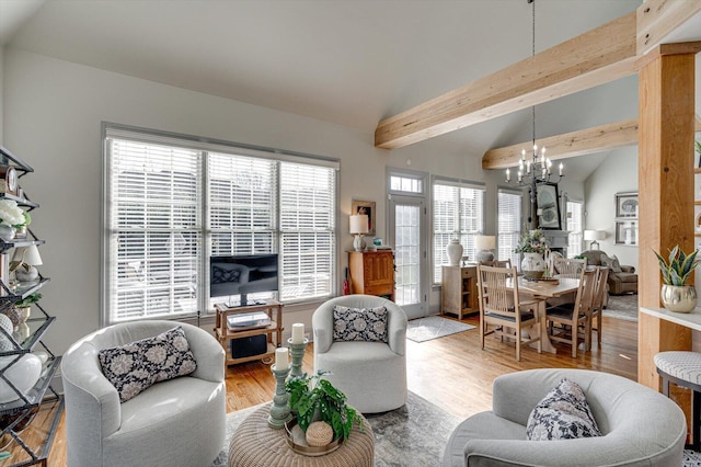 living room with hardwood / wood-style floors, vaulted ceiling with beams, and a notable chandelier