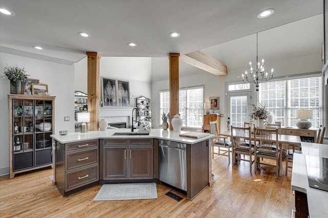 kitchen with dark brown cabinetry, sink, pendant lighting, dishwasher, and light hardwood / wood-style floors