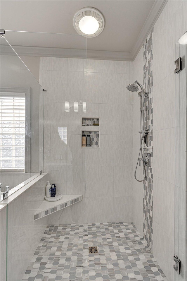 bathroom featuring a tile shower and ornamental molding