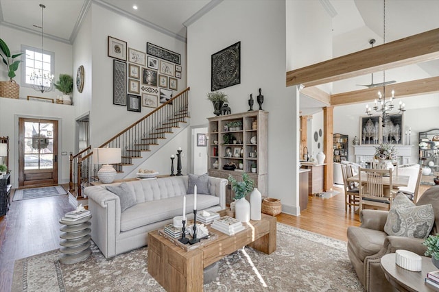 living room featuring a wealth of natural light, an inviting chandelier, a high ceiling, and hardwood / wood-style flooring