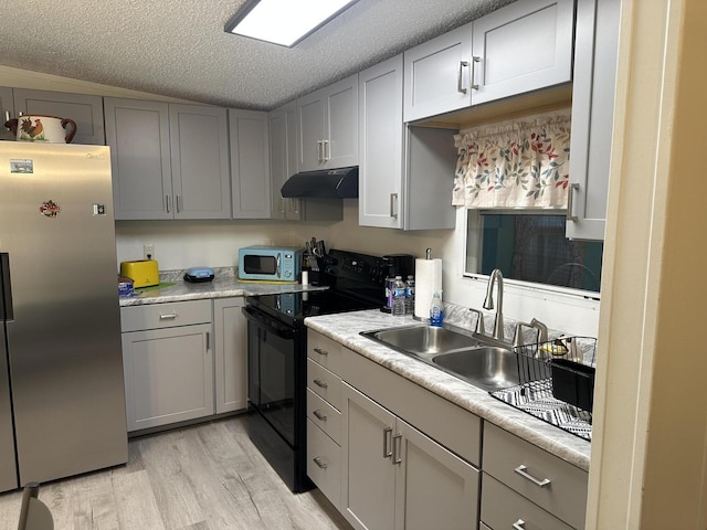 kitchen featuring gray cabinetry, sink, light hardwood / wood-style flooring, a textured ceiling, and stainless steel appliances