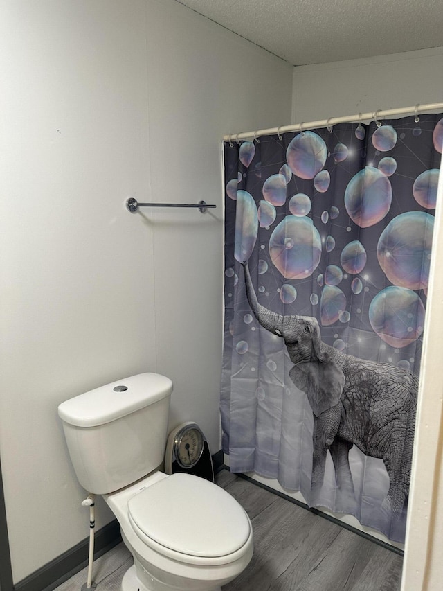 bathroom featuring hardwood / wood-style floors, a textured ceiling, and toilet