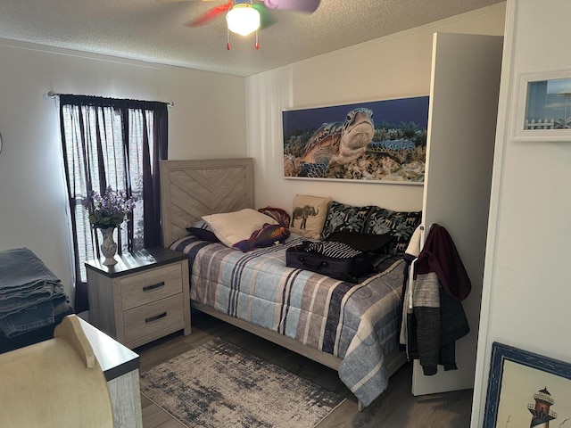 bedroom with ceiling fan, hardwood / wood-style floors, and a textured ceiling