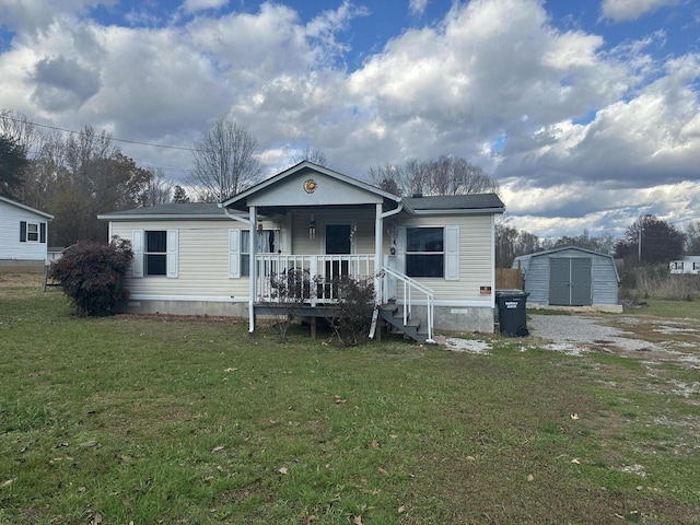 view of front facade with a front lawn, covered porch, and a shed