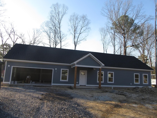 ranch-style house with a porch, an attached garage, and driveway