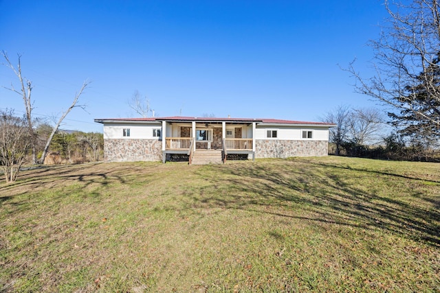 rear view of house with covered porch and a yard