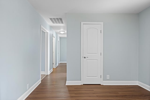 empty room with dark hardwood / wood-style flooring