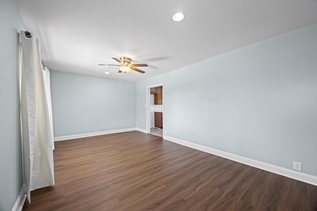 spare room with ceiling fan and dark wood-type flooring