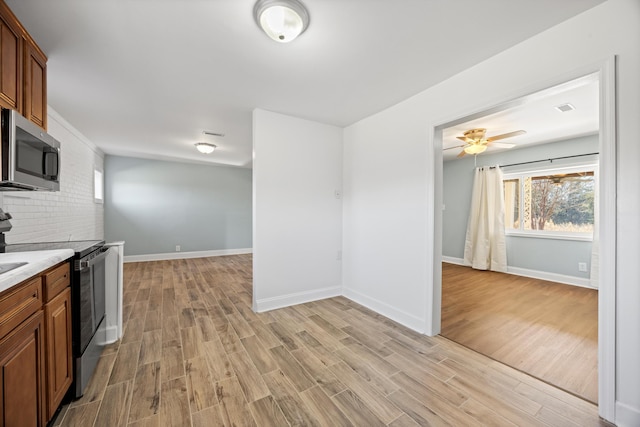 kitchen with ceiling fan, light hardwood / wood-style flooring, and stainless steel appliances