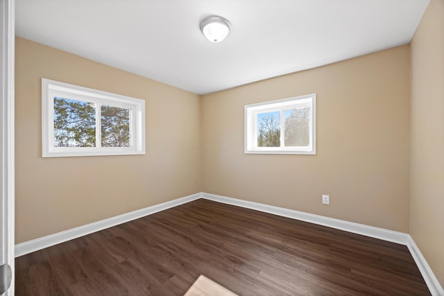 spare room with plenty of natural light and dark hardwood / wood-style floors