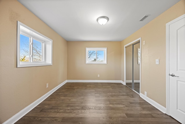 unfurnished bedroom featuring dark hardwood / wood-style floors and a closet