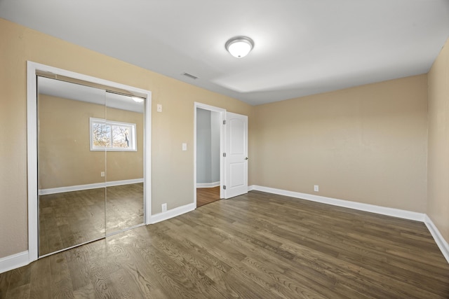 unfurnished bedroom with hardwood / wood-style floors and a closet