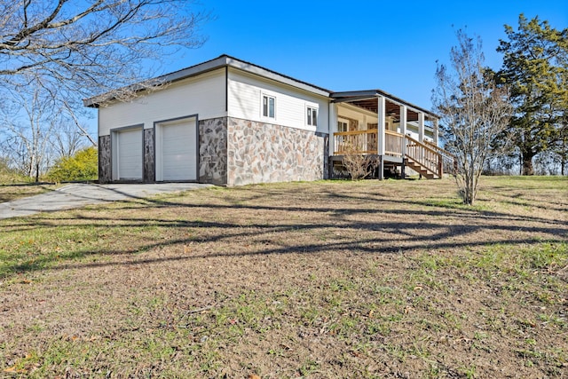 view of side of home featuring a porch and a yard