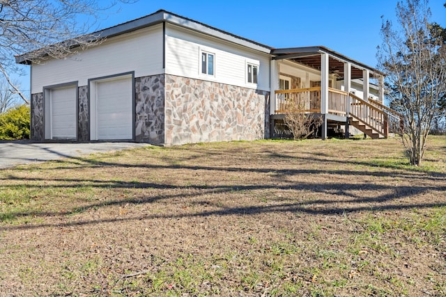 view of side of property with a lawn, a porch, and a garage