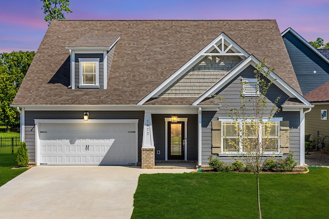 craftsman-style house featuring a lawn and a garage