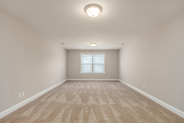 unfurnished room featuring light colored carpet