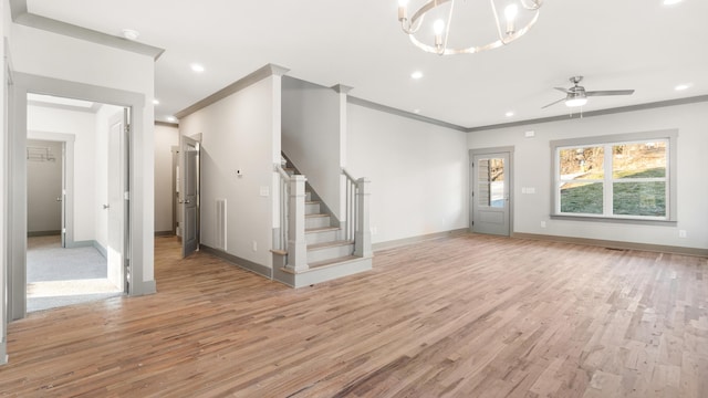 unfurnished living room with crown molding, ceiling fan with notable chandelier, and light hardwood / wood-style flooring