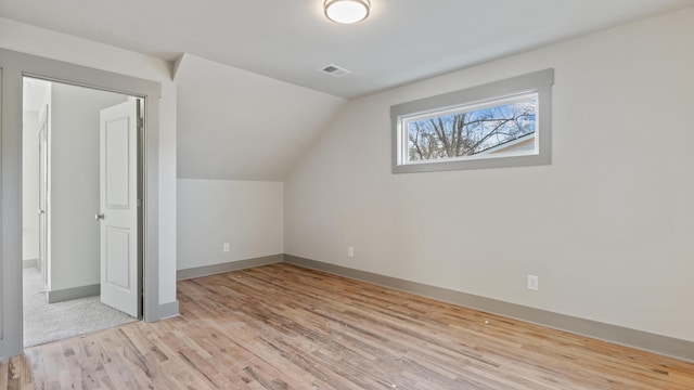 bonus room featuring lofted ceiling and light hardwood / wood-style flooring