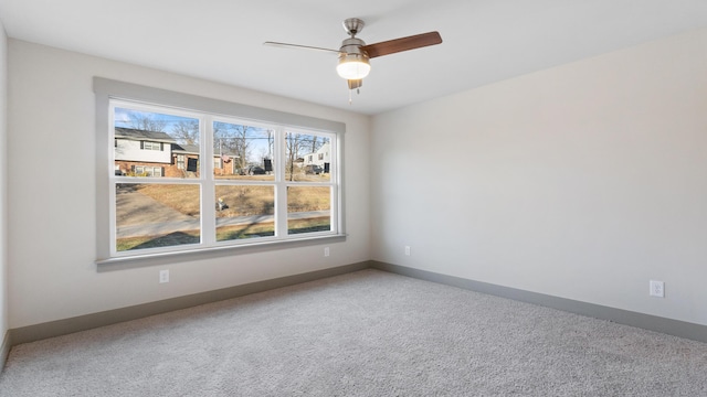 carpeted spare room with ceiling fan