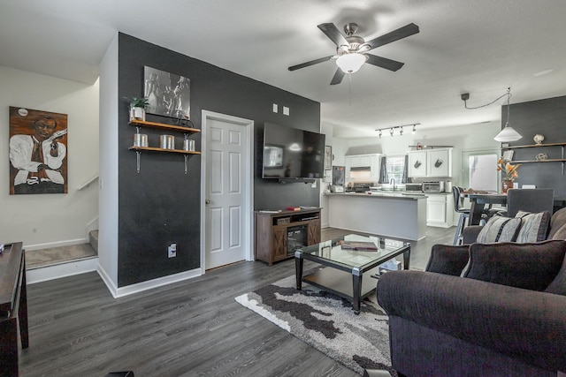 living room with ceiling fan, dark hardwood / wood-style floors, sink, and track lighting