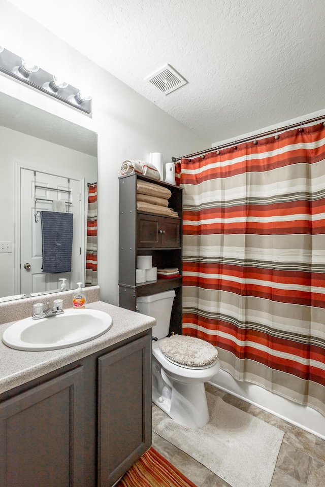 bathroom with vanity, a textured ceiling, toilet, and curtained shower