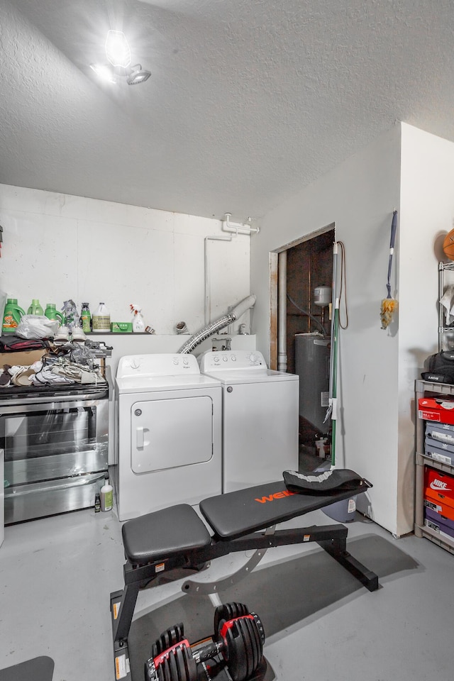 washroom with a textured ceiling, washer and clothes dryer, and water heater