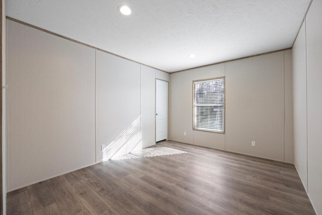 unfurnished room with hardwood / wood-style floors and a textured ceiling