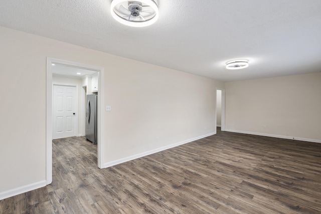 empty room featuring dark wood-type flooring and a textured ceiling