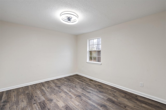 unfurnished room with dark hardwood / wood-style flooring and a textured ceiling