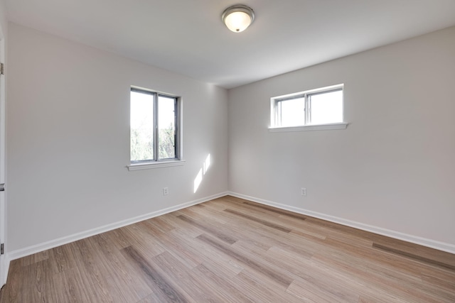 spare room with light hardwood / wood-style floors and plenty of natural light