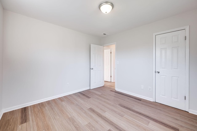 unfurnished bedroom with light hardwood / wood-style floors and a closet