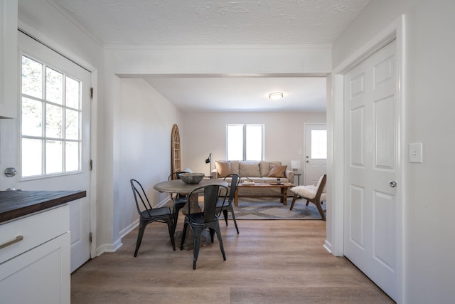 dining room featuring a textured ceiling, light hardwood / wood-style floors, and plenty of natural light