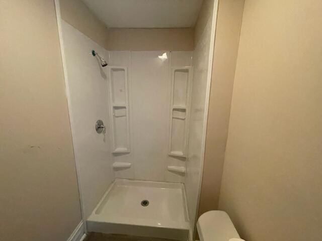 bathroom featuring toilet and walk in shower