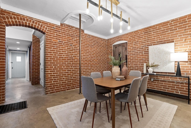 dining space with concrete flooring and brick wall