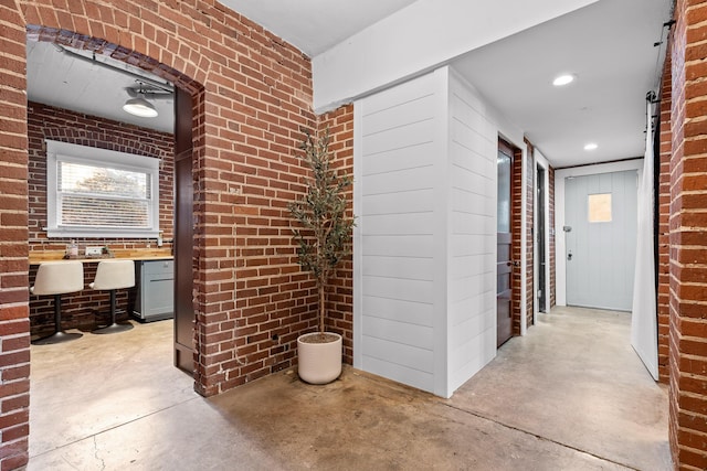 hall with a healthy amount of sunlight and brick wall