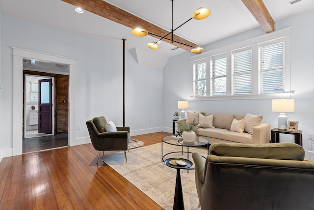 living room with lofted ceiling with beams and light hardwood / wood-style floors