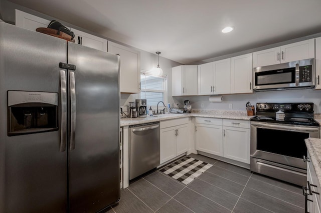 kitchen featuring appliances with stainless steel finishes, white cabinetry, pendant lighting, and sink