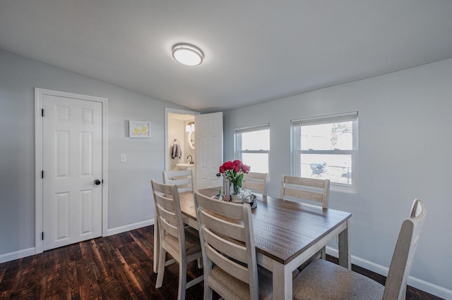 dining space featuring dark hardwood / wood-style flooring and vaulted ceiling