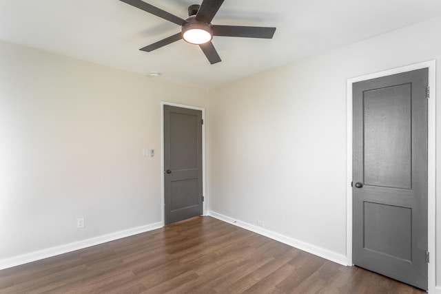 empty room with ceiling fan and dark hardwood / wood-style flooring